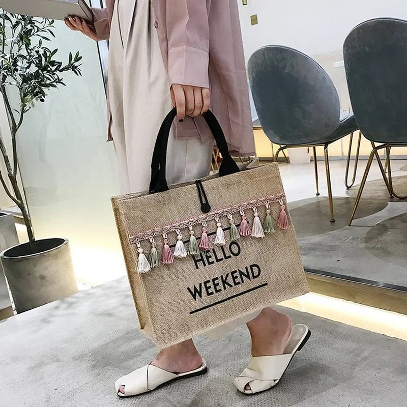 Large capacity tassel straw handbag with letter and tassel decoration.